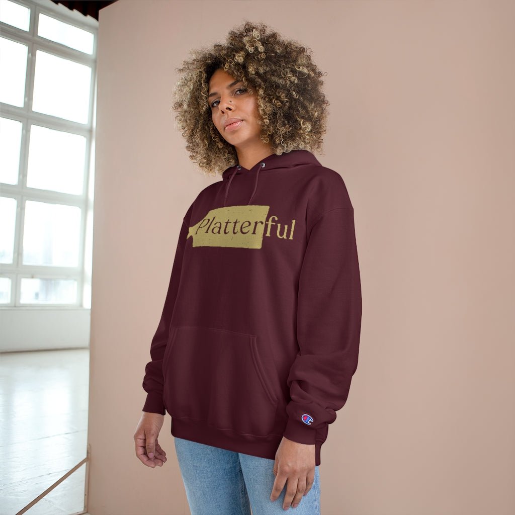 A maroon Champion hoodie with a gold Platterful logo on the front.
