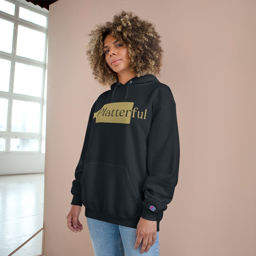 A black Champion hoodie with a gold Platterful logo on the front.