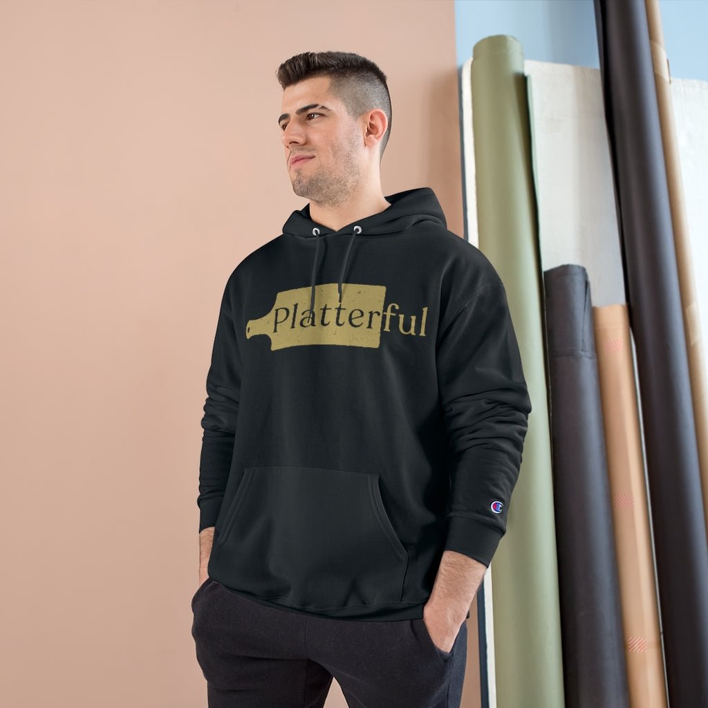 A black Champion hoodie with a gold Platterful logo on the front.