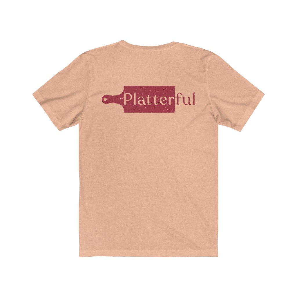 The back of a heather peach colored T-shirt with the Platterful logo in the middle.