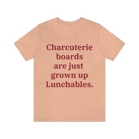 A heather peach colored T-shirt that reads "Charcuterie boards are just grown up Lunchables." in red text.