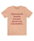 A heather peach colored T-shirt that reads "Charcuterie boards are just grown up Lunchables." in red text.