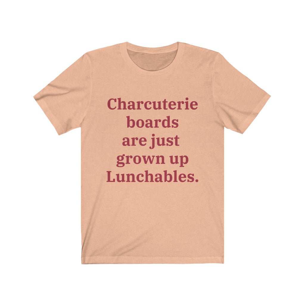 A heather peach colored T-shirt that reads "Charcuterie boards are just grown up Lunchables." in red text.