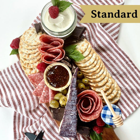 Standard Platterful Charcuterie Kit - Cheese, meat, crackers, spreadables, olives, nuts and chocolates. Everything you need to create the best charcuterie board that is sure to leave your friends and family drooling.  Estimated serving size: Small charcuterie board feeds 2-4 as a small appetizer or 1-2 as a meal