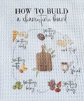 Kitchen towel with instructions on how to build a charcuterie board.