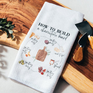 Kitchen towel with instructions on how to build a charcuterie board.